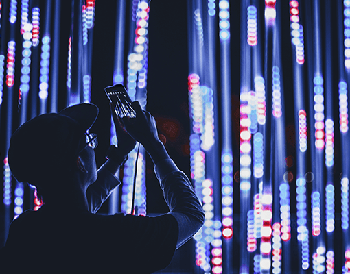 A man taking a picture of lights.