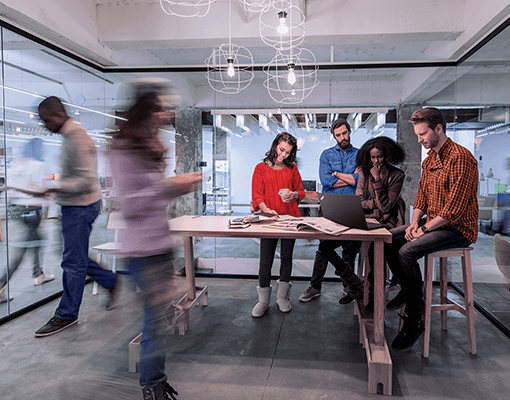 A group of people discussingover a Lenovo ThinkPad.